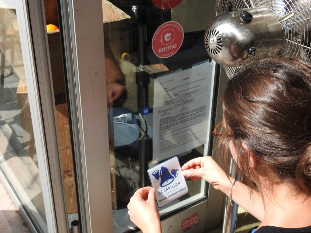 Femme posant le logo la cloche sur une porte de restaurant